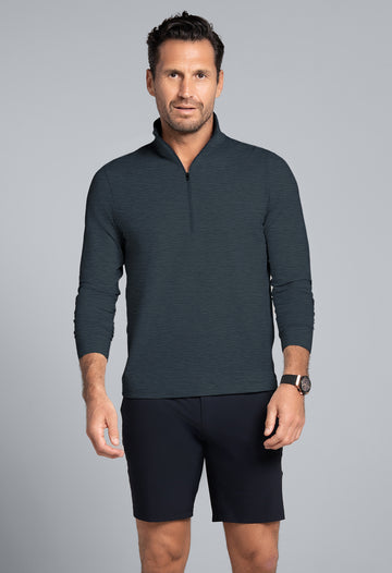 Man wearing a dark gray long-sleeve shirt and black shorts on a gray background