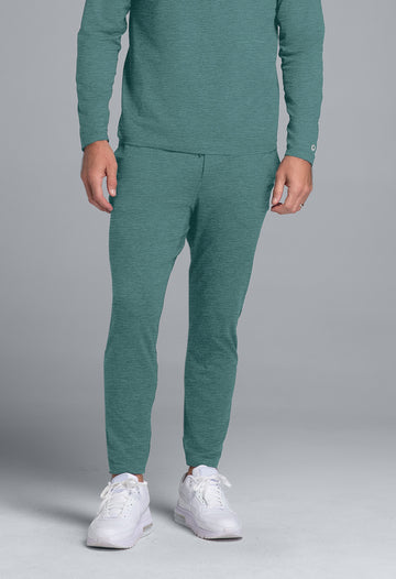 Person wearing a teal tracksuit with white sneakers on a gray background
