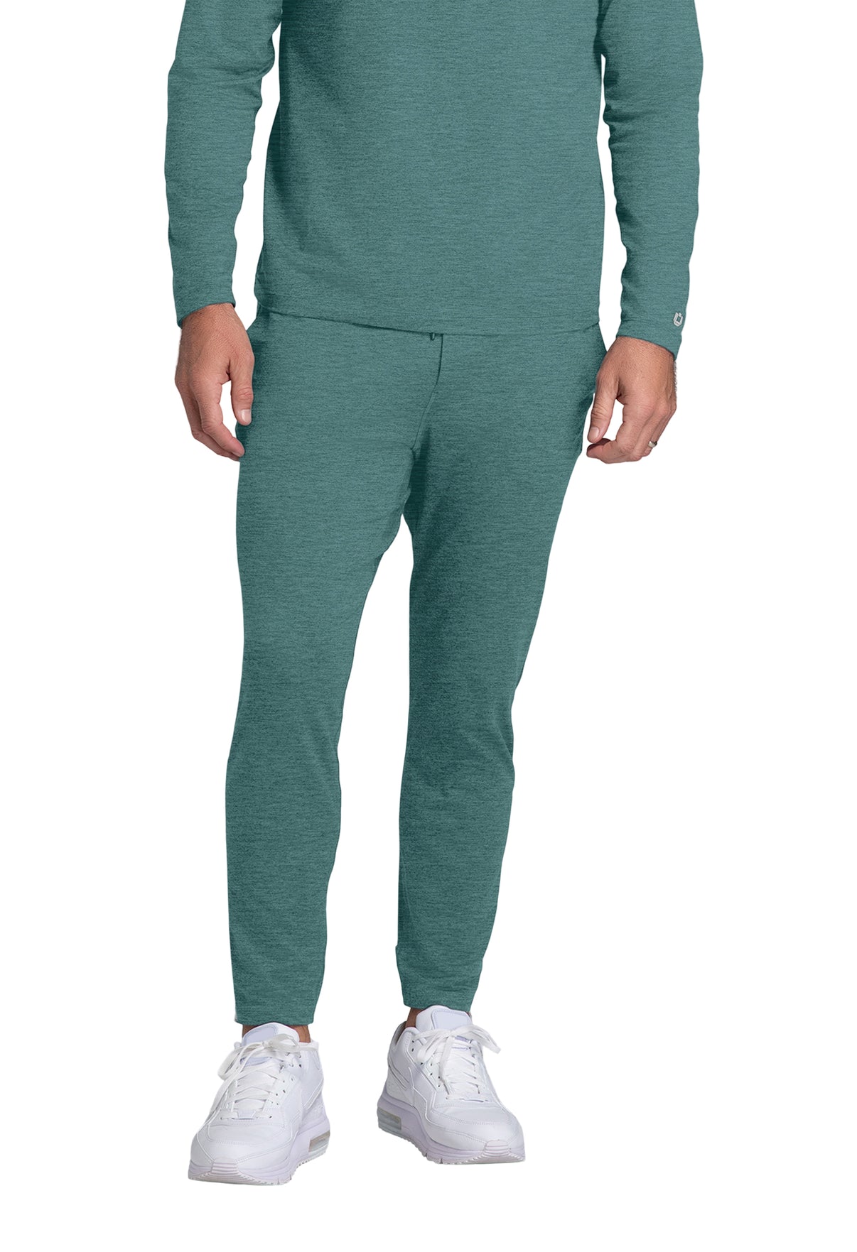 Person wearing a teal tracksuit with white sneakers on a white background